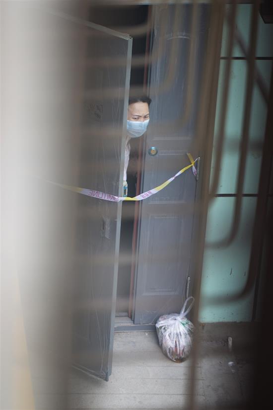 7月29日，乌鲁木齐市疫情防控措施依然严格，一个小区的单元门被拉上了隔离带，小区居民积极配合，封闭在家。买菜由志愿者送上门，倒垃圾也是服务到家。任春山/人民视觉 图